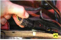 5. Сожмите фиксаторы и разъедините колодку жгута проводов топливного насоса.