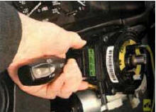4. Сожмите фиксаторы и извлеките переключатель указателей поворота и света фар