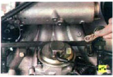 9. Выверните два болта крепления топливной рампы к впускной трубе…