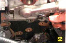 6. Выверните два болта крепления крышки гнезда термостата…