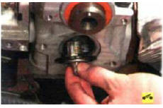 8. Поддев отверткой, извлеките из гнезда в головке блока цилиндров термостат