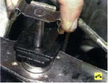 2. ...и извлеките ось из отверстий шарнира рычага и кронштейна задней опоры силового