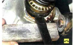 7. Уперев монтажную лопатку в картер коробки передач через деревянную проставку,