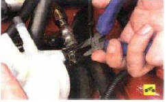 5. Снимите отводящий шланг, для чего сожмите отогнутые усики хомута пассатижами