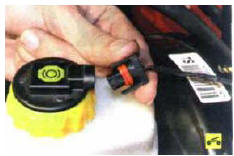 1. Разжав фиксаторы, отсоедините колодку жгута проводов от пробки бачка главного