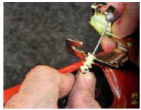 5. ...наконечник оболочки троса из прорези корпуса замка и снимите замок.